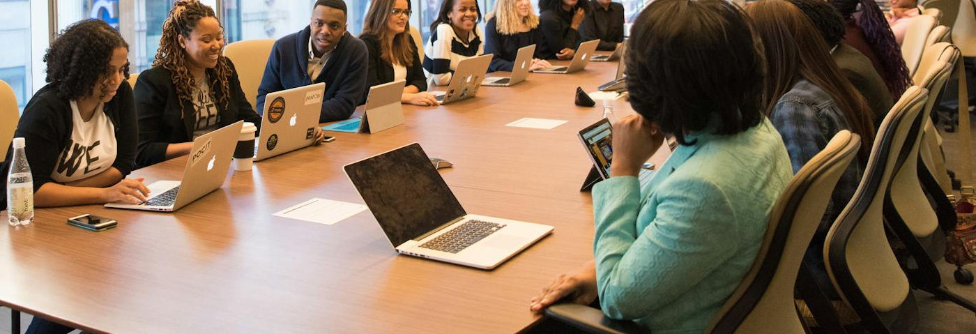 A group of professionals engaged in a meeting, discussing debt recovery strategies and ideas in a modern conference room setting.